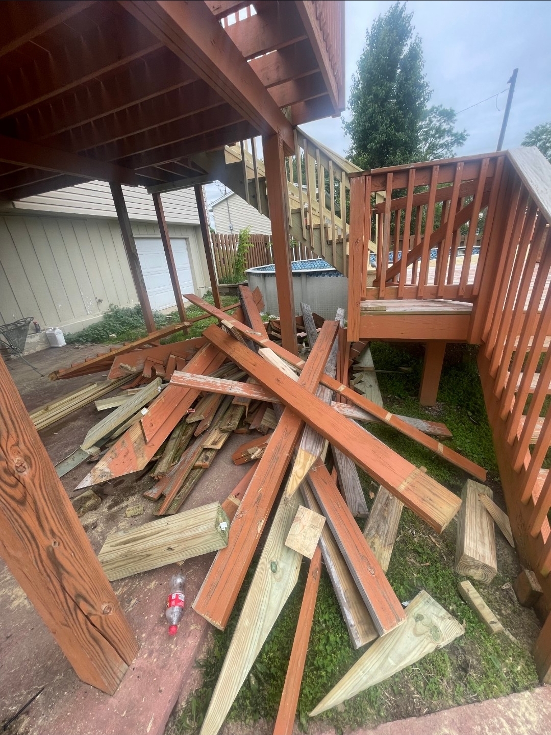 Deck demolition in progress with debris pile